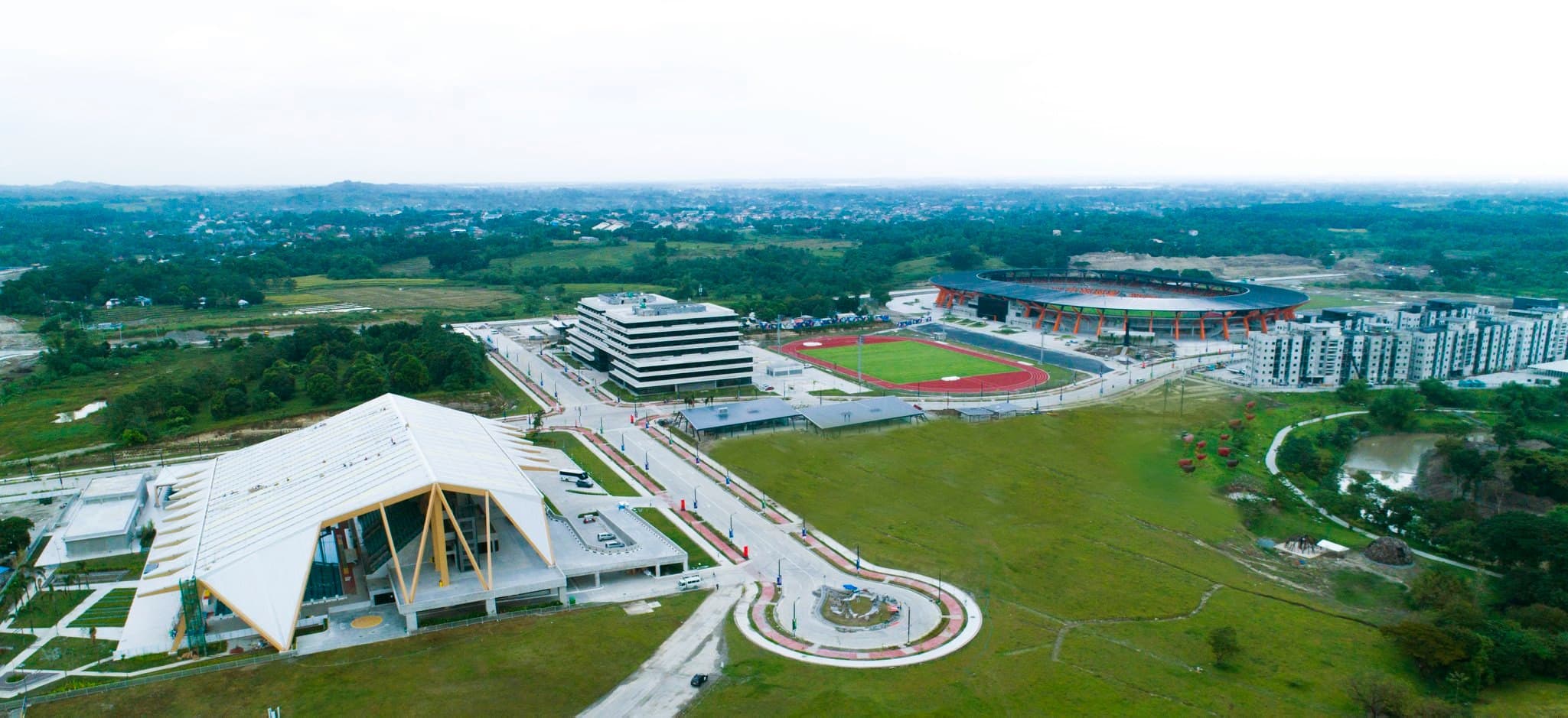 Aerial view of New Clark City Sports Hub in Capas, Tarlac, surrounded by roads and green land.